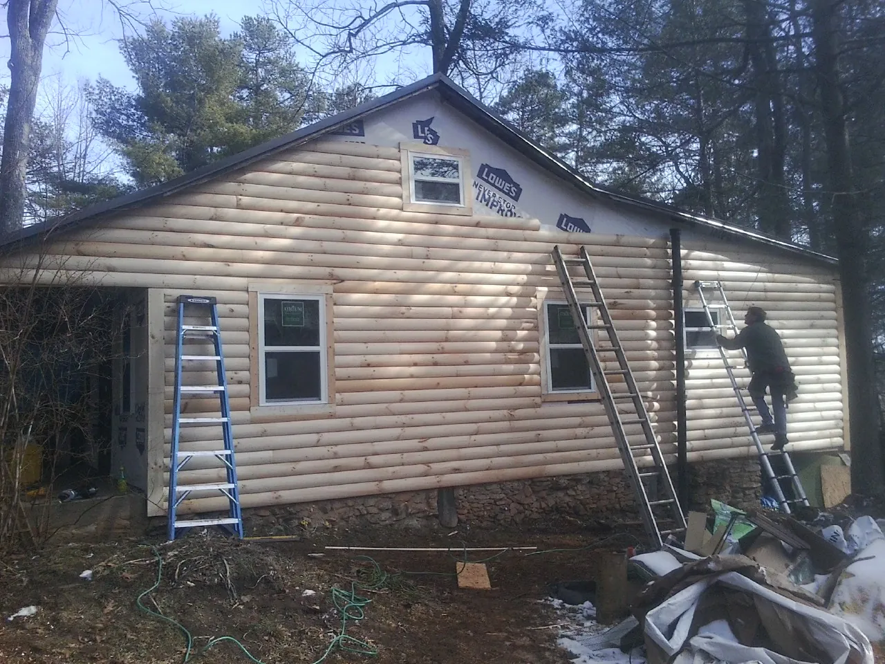 Ladders set against fresh log siding during an exterior remodel in Twin Lakes