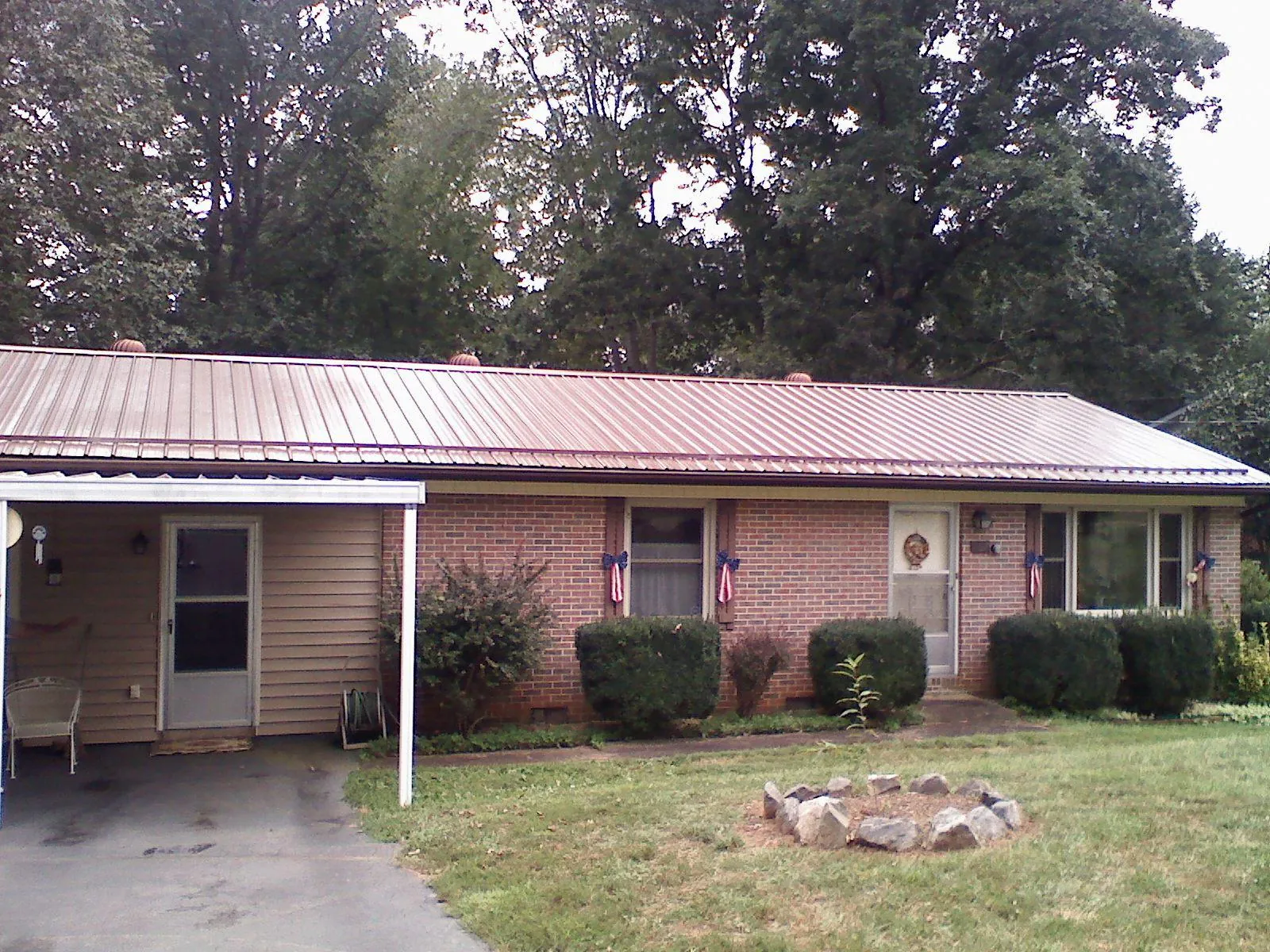 Bronze metal roof and carport on a brick ranch home — Roof Repair work by our crew in Twin Lakes
